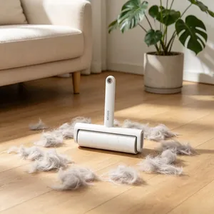 Close-up of portable lint roller removing grey pet hair from a wooden floor surface