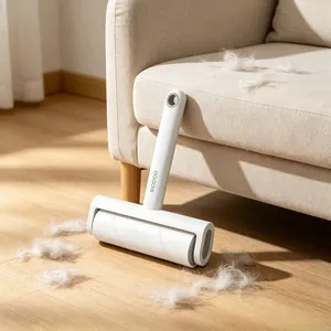 Close-up of white lint roller with hanging hole leaning against a beige fabric sofa