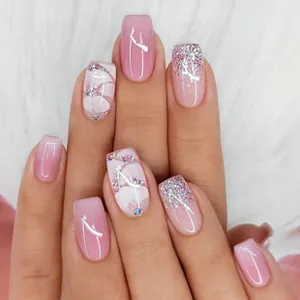 Close-up of pink and white long French press-on nails with star rhinestones and marble patterns