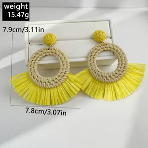 Detail view of yellow raffia flower earrings showing 7.9cm length and weight measurement
