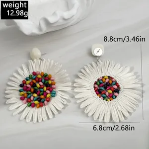 Detailed view of bohemian raffia flower earrings with size measurements and weight info