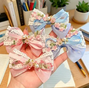 Lace and satin bow hair clips with embroidery and pearl accents for girls in a 4-piece set