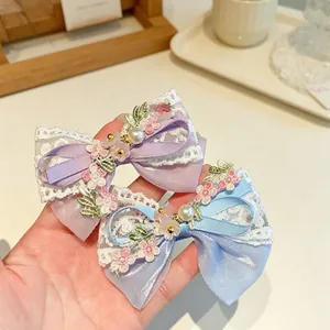 Close-up of handmade lace bow hair clips with pearls in purple and blue colors