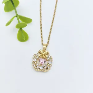 Elegante collana dorata con fiocco e pendente a cuore di cristallo rosa con zirconi
