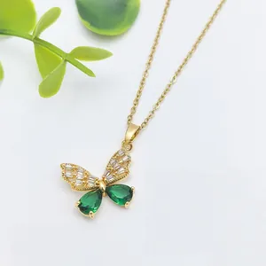Collana a farfalla dorata con ali in zircone verde e una delicata catena a croce