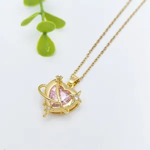 Collana a cuore dorata con ciondolo pianeta in zircone rosa e dettaglio anello stellato