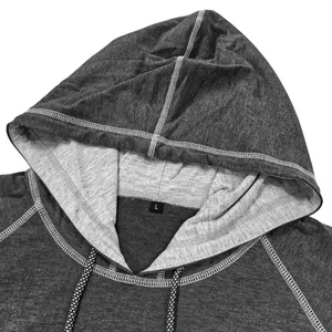 Dettaglio felpa con cappuccio grigia con coulisse a scacchi e fodera del cappuccio a contrasto