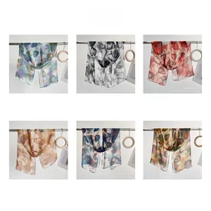 Detail view of six elegant lightweight long scarves featuring layered leaf patterns