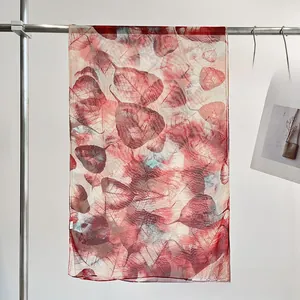 Macro detail of lightweight leaf print chiffon scarf with elegant red vein patterns