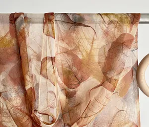 Detail of thin leaf pattern silk scarf with translucent texture on a metal rack