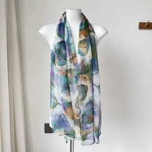 Detail of lightweight printed scarf showing realistic leaf vein patterns and semi-sheer fabric
