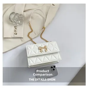 White quilted crossbody bag with gold bow buckle compared to a smartphone for size