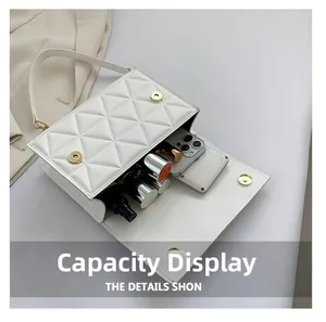 Interior view showing the large capacity of this white quilted flap bag with gold hardware