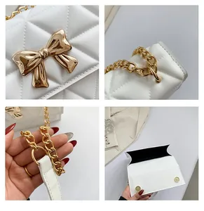 Close-up of golden bow hardware and diamond quilted stitching on white leather crossbody bag