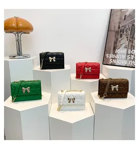 Detailed view of quilted flap crossbody bags with golden bow clasps and chain straps