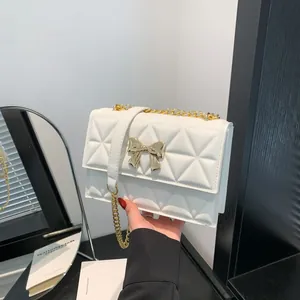 Elegant white quilted shoulder bag with gold bow clasp and chain strap for women