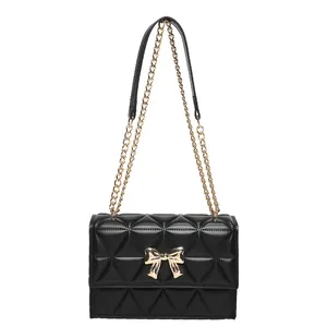 Classic black quilted shoulder bag with golden bow hardware and chain strap details