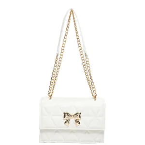 Elegant white quilted crossbody bag with gold bow clasp and metal chain strap
