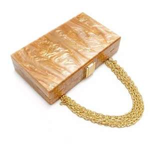 Acrylic marble patterned clutch bag with amber swirls and gold chain for evening parties