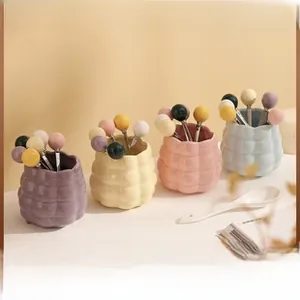Detail of luxury ceramic storage jars with wavy texture and colorful dessert forks