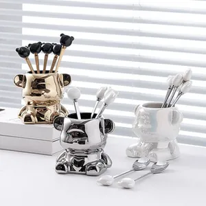 Detailed view of luxury bear ceramic storage jar and decorative spoons in various metallic finishes