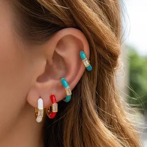 Close-up of colorful enamel hoop earrings and ear cuffs with baguette-cut cubic zirconia