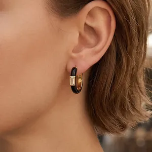 Minimalist gold hoop earrings with black enamel and rectangle zircon on earlobe