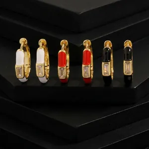 Detail of gold enamel hoop earrings with rectangular cubic zirconia in white, red, and black