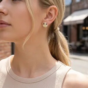 Close-up of 18K gold smiley face stud earrings with zircons worn by a model