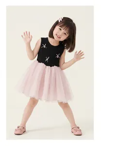 Detailed view of girl's dress with pink bows, beaded accents and tiered tulle skirt