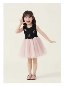 Detail of girls' dress with pink mesh tutu skirt and decorative pearl bow accents