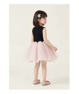 Side view of girl in sleeveless tutu dress with pink bow and mesh skirt for formal events