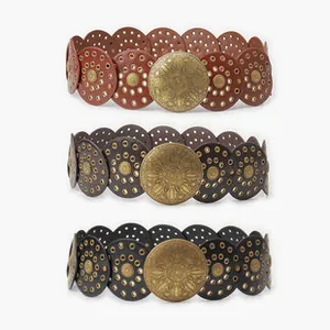 Detail of vintage bohemian wide belts with hollow circular patterns and metal buckles