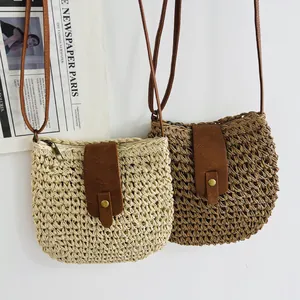 Detail of hollow woven paper bucket bag with faux leather strap and vintage metal buckle