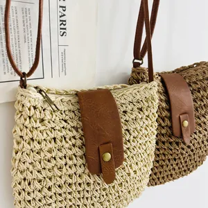 Detailed view of handmade woven paper bucket bags in beige and brown with faux leather straps