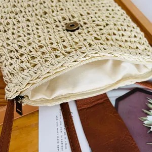 Close-up of woven paper bucket bag showing the texture, zipper and metal buckle details