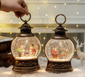 Macro detail of retro bronze Christmas lantern snow globe with Santa and snowman scenes