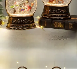 Detail of Christmas lantern snow globe with snowman, elk and vintage embossed metal base