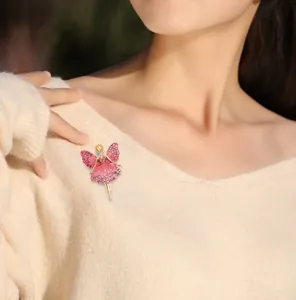 Detail of ballet dancer brooch with pink rhinestones on a beige knit sweater