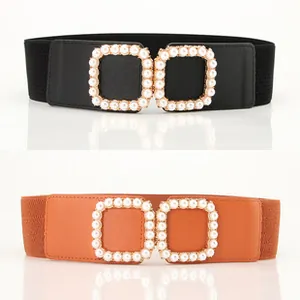 Detail of wide elastic belts with dual square buckles and faux pearl embellishments