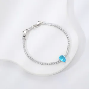 Silver tennis bracelet with round white zircons and a blue pear-shaped drop stone