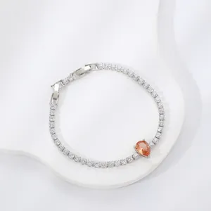 Detail of silver tennis bracelet with sparkling zircons and a pear-cut champagne stone