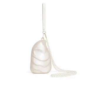 Detail of shell-shaped acrylic clutch with pearl chain strap and pearlized finish