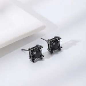 Macro shot of square black zircon stud earrings with gunmetal plating on white base