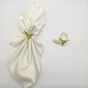 Elegant lily of the valley napkin rings in white and sky blue with gold metal finish