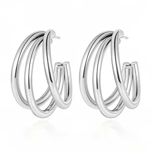 Detail of silver triple-layered C-shape hoop earrings with high-polish metallic finish