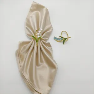 Detailed view of lily of the valley napkin rings with white and blue enamel flowers