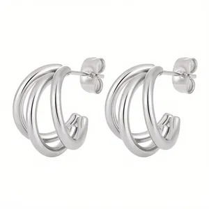 Detail view of triple-layered silver C-shaped hoop earrings with polished metal finish