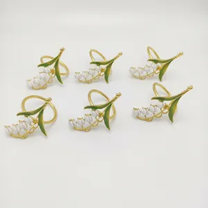 Set of 6 gold lily of the valley napkin rings with white enamel flowers and green leaves