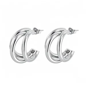 Macro detail of triple-layered C-shape silver metal earrings with high-polished mirror finish